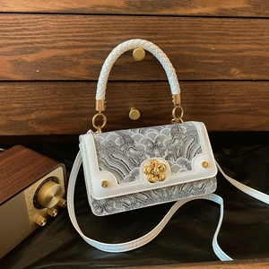 Sac bandoulière vintage avec bordure en cuir blanc et broderies sur bois sombre
