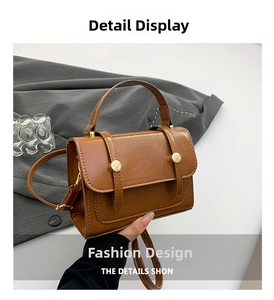 Detailansicht der braunen Retro-Handtasche mit goldener Metallschnalle und Griff oben