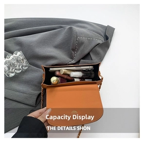 Vue de dessus d'un sac à rabat orange contenant un téléphone, parfum et rouge à lèvres