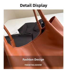 Detailed view of the brown leather tote bag with reinforced double stitching and texture