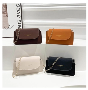 Détail de quatre mini sacs à rabat en marron, orange, beige et noir avec chaîne