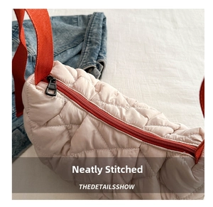 Close-up of quilted light pink tote bag with glossy finish and red fabric strap