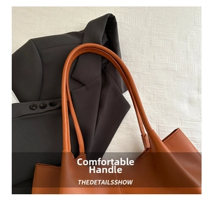 Close-up of thick brown leather handle on a tote bag with premium textured finish