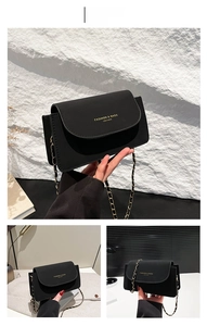 Détail du sac à bandoulière en cuir noir avec bandoulière chaîne et logo doré