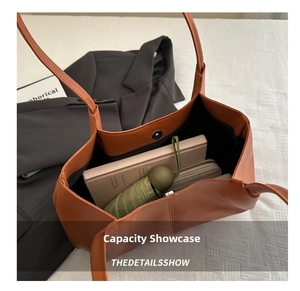 Interior view showing the large capacity of the caramel leather tote bag with various items