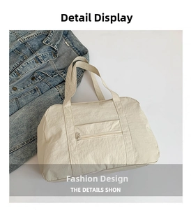 Close-up of beige waterproof nylon travel bag with front zipper and woven handles