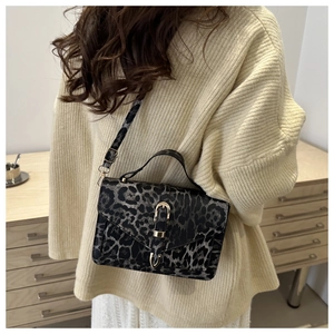 Detailed close-up of leopard print shoulder bag with gold buckle and textured leather