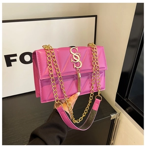 Close-up of rose red quilted PU leather handbag with gold S-buckle and tassel detail