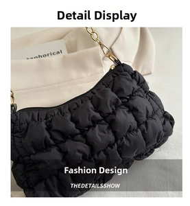 Detail of black quilted bubble bag featuring soft nylon texture and golden chain strap
