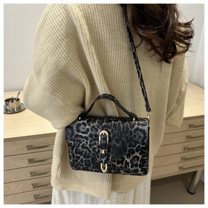 Detail of leopard print crossbody bag with gold buckle and adjustable strap on model