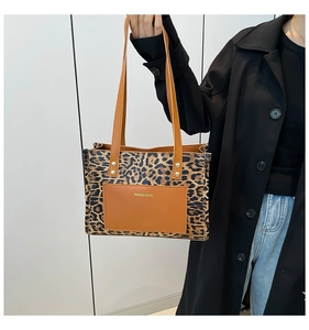 Gros plan du sac cabas léopard avec poche frontale en cuir marron et logo de mode