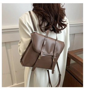 Detail of vintage brown PU leather backpack with buckle straps and adjustable shoulder straps