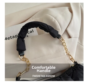 Close-up of ruched cloud bag with padded handle and elegant gold chain link details