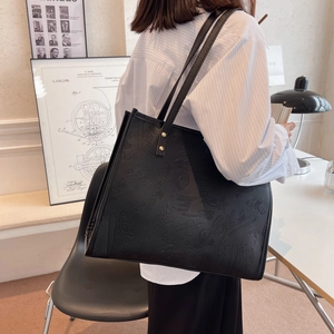 Large black tote bag with embossed graffiti design and long straps for women's daily commute
