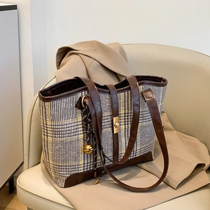 Retro houndstooth tote bag with brown leather trim and gold twist lock on leather seat