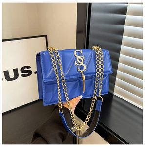 Detail of royal blue quilted leather chain bag with gold SS logo and tassel