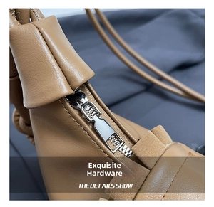 Close-up of durable silver metal zipper and neat stitching on brown leather bag