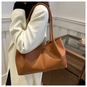 Detail of soft brown faux leather tote bag with vertical stitching and fine texture