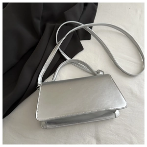 Dettaglio borsa a mano trapezoidale argento metallizzato con manico e finitura lucida