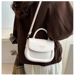 Rear view of model wearing a stylish white PU leather handbag with gold lettering