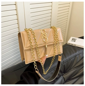 Close-up of beige quilted crossbody bag with gold SS hardware and tassel detail