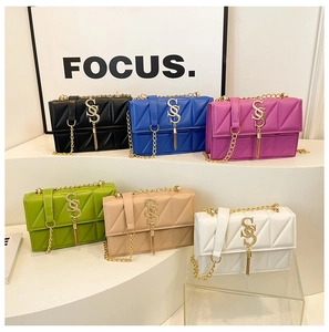 Detail of quilted crossbody bags with gold metal chain straps and decorative tassels