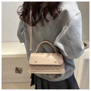 Dettaglio borsa beige a tracolla con goffratura a scacchiera e fibbie rotonde eleganti