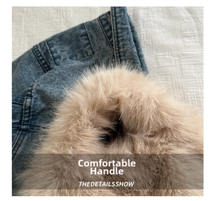 Detailed close-up of denim fabric stitching with plush faux fur trim on a winter tote bag