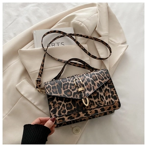 Close-up of leopard print handbag with golden metal buckle and textured leather material