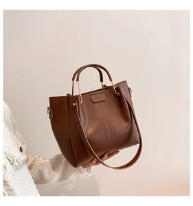 Detailed macro view of brown vintage tote bag with gold hardware and leather texture