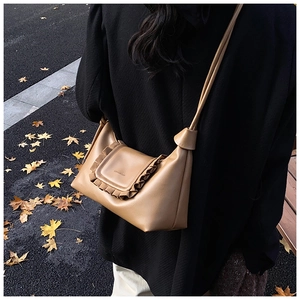 Detail of khaki ruffle cloud bag with matte leather texture and elegant wavy edge design