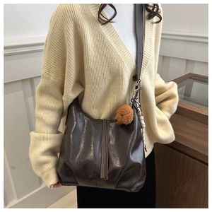 Détail du sac cabas en cuir PU marron brillant avec breloque d'ours et foulard chic