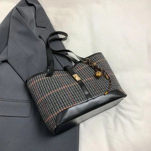 Large plaid wool tote bag with leather trim and gold twist lock shown from 45-degree angle
