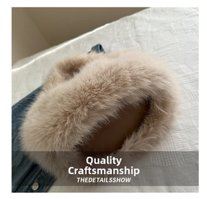 Detail of premium fluffy beige faux fur collar on denim jacket with soft texture