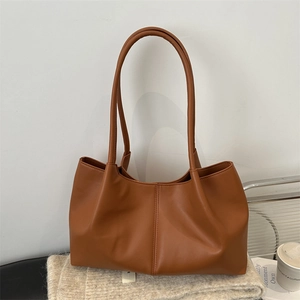 Brown pleated PU leather tote bag with long handles displayed on a warm knit sweater