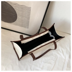 Detail view of large canvas tote bag interior with zip pocket and brown leather trim