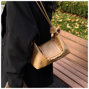 Detail of light brown drawstring cloud bag with pleated ruffle edges and long shoulder strap