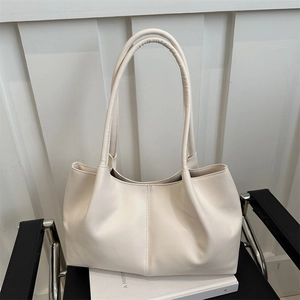 Minimalist cream tote bag with vertical stitching on a black chair, large capacity style