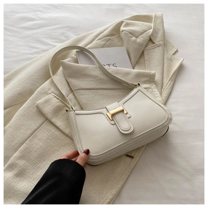 Detailed view of white leather underarm bag with elegant gold metal buckle and matte texture