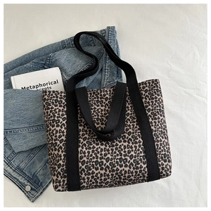 Vue détaillée du sac cabas en toile à imprimé léopard avec veste en jean et livres de mode