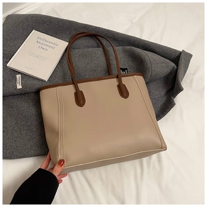Detail view of the large capacity tote bag featuring beige and brown patchwork design