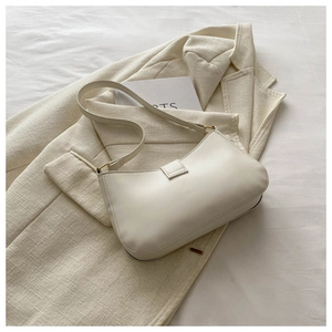 Detail of minimalist beige faux leather shoulder bag with decorative strap buckle