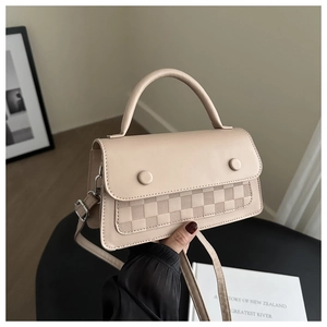 Dettaglio borsa beige in ecopelle con trama a scacchiera 3D e bottoni decorativi