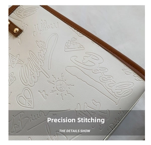 Macro view of white lychee leather texture with clover embossing and gold stud detailing