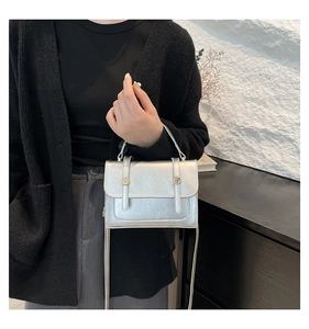 Detail showing the silver metallic texture and fold texture on the stylish square bag