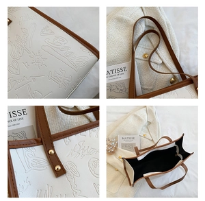 Detail of white tote bag with embossed graffiti patterns and brown leather handles