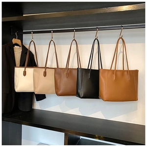 Detailed row of minimalist leather tote bags in cream, beige, brown, and black colors