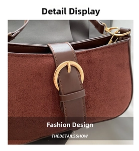 Close-up of frosted matte leather texture and golden round buckle on the reddish-brown bag