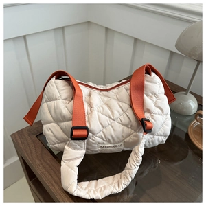 Detailed quilted puffer bag in beige with orange straps and a minimalist label