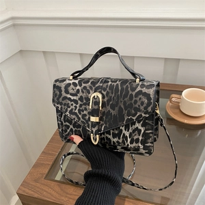 Fashionable leopard print crossbody bag with golden horseshoe buckle and top handle